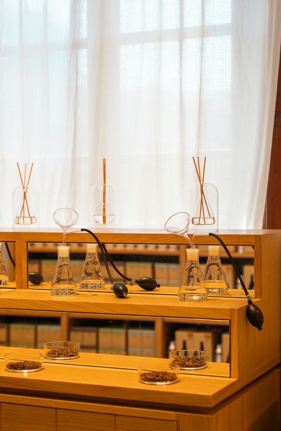 Glass diffusers and beakers on wooden shelves.