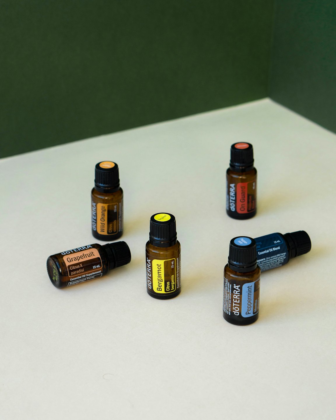 Six amber glass essential oil bottles arranged on a white surface.